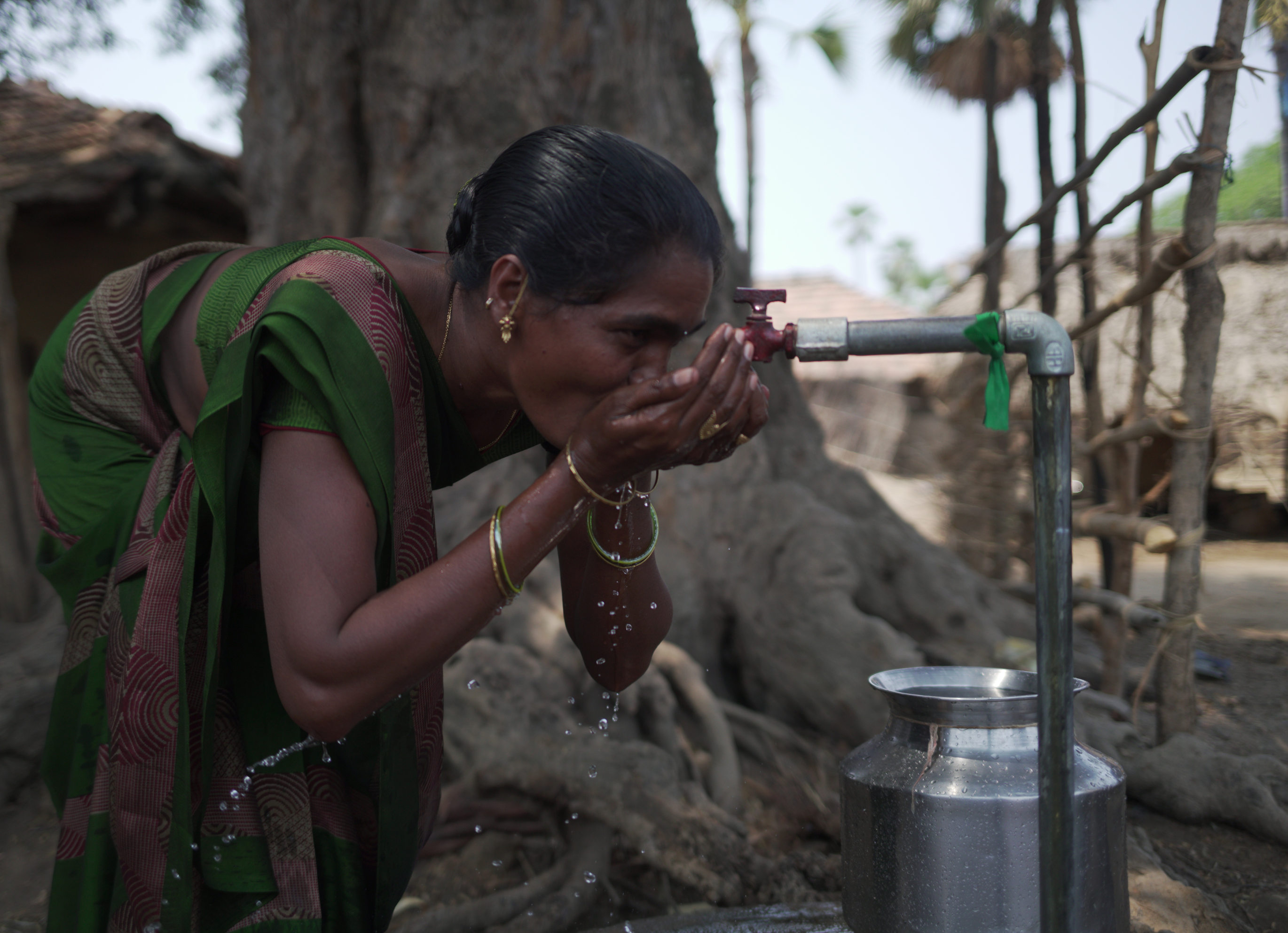 Woman drinking water from a tap